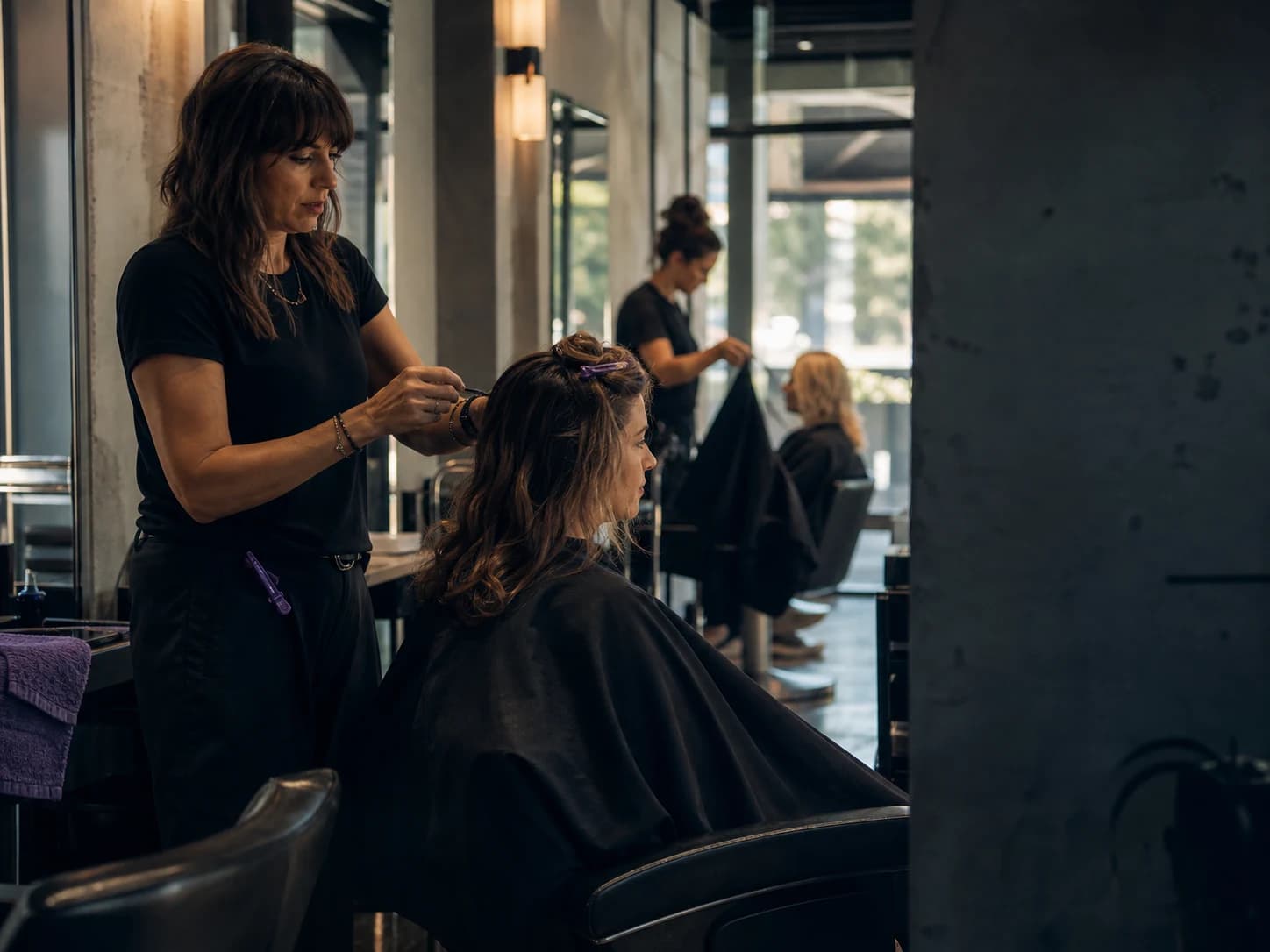 A salon owner and team serving clients while the publishing schedule stays in motion